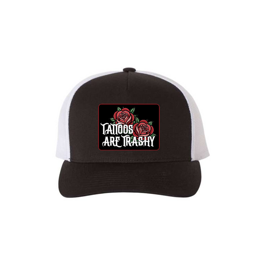 Tattoos Are Trashy Roses 5-panel trucker hat in black with white mesh, front product mockup showing a black patch with red roses and white lettering.