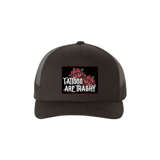 Tattoos Are Trashy Roses 5-panel trucker hat in black, front product mockup showing a black patch with red roses and white lettering.