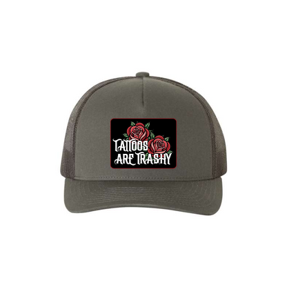 Tattoos Are Trashy Roses 5-panel trucker hat in charcoal, front product mockup showing a black patch with red roses and white lettering.