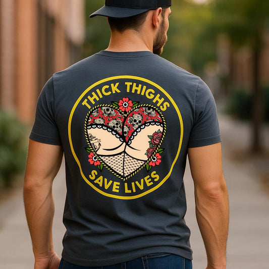 Model wearing a charcoal Thick Thighs Save Lives graphic T-shirt, back view showing the circular slogan design.